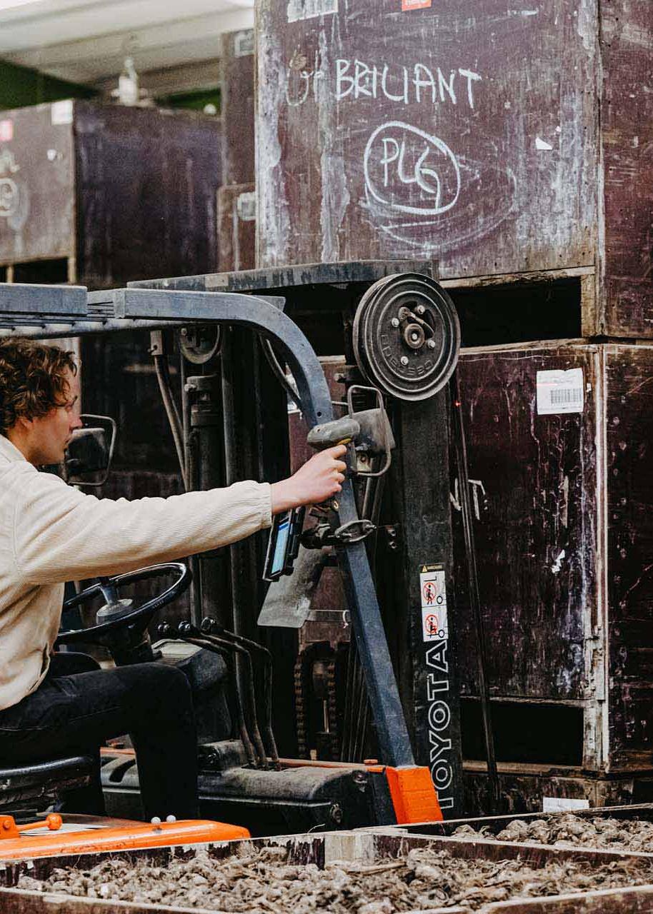 Man in heftruck scant label op grote kist.