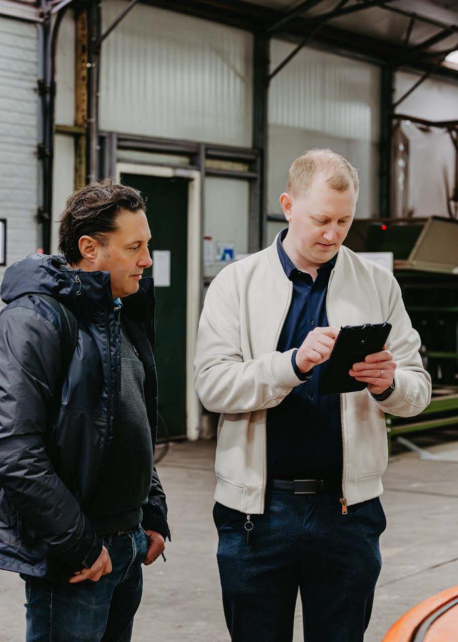Twee mannen kijken samen op een tablet.