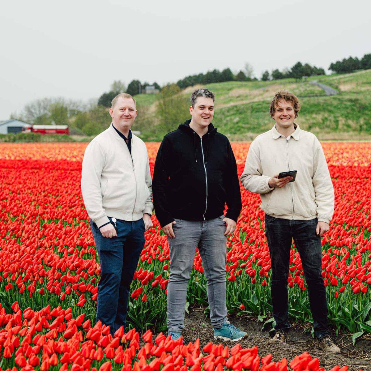 Smart Bulb consultants met een klant tussen de tulpen in het veld.