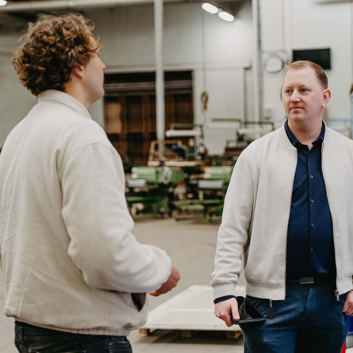 Smart Bulb softwareconsultant in gesprek met kweker in een fabriekshal.