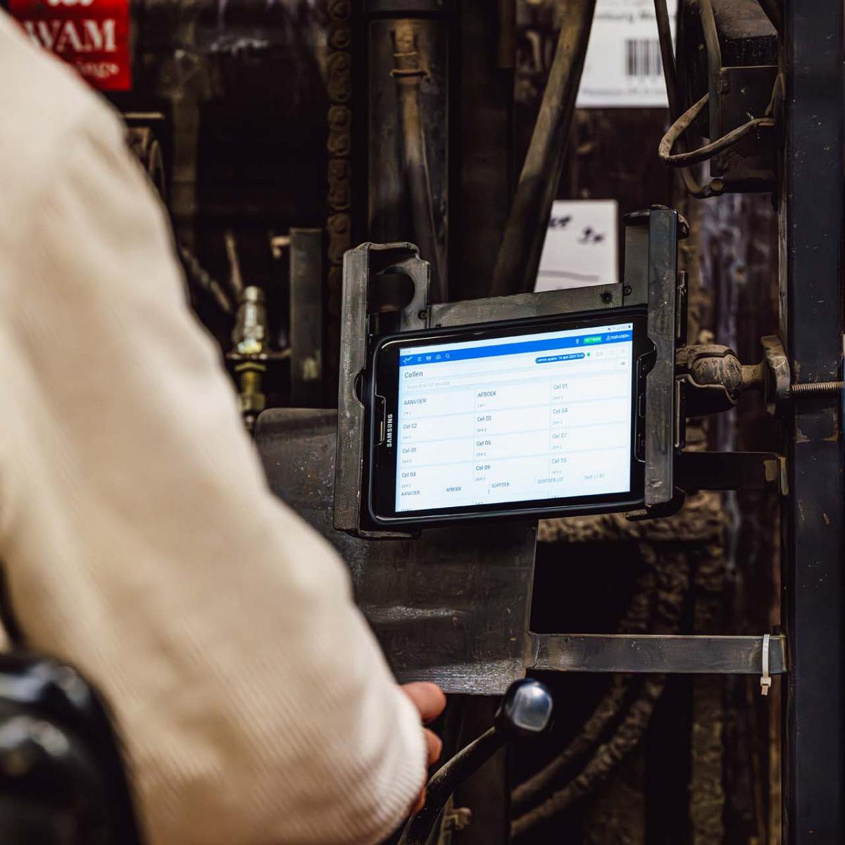 Tablet bevestigd aan een industriële machine met een geopende applicatie die verschillende data toont.