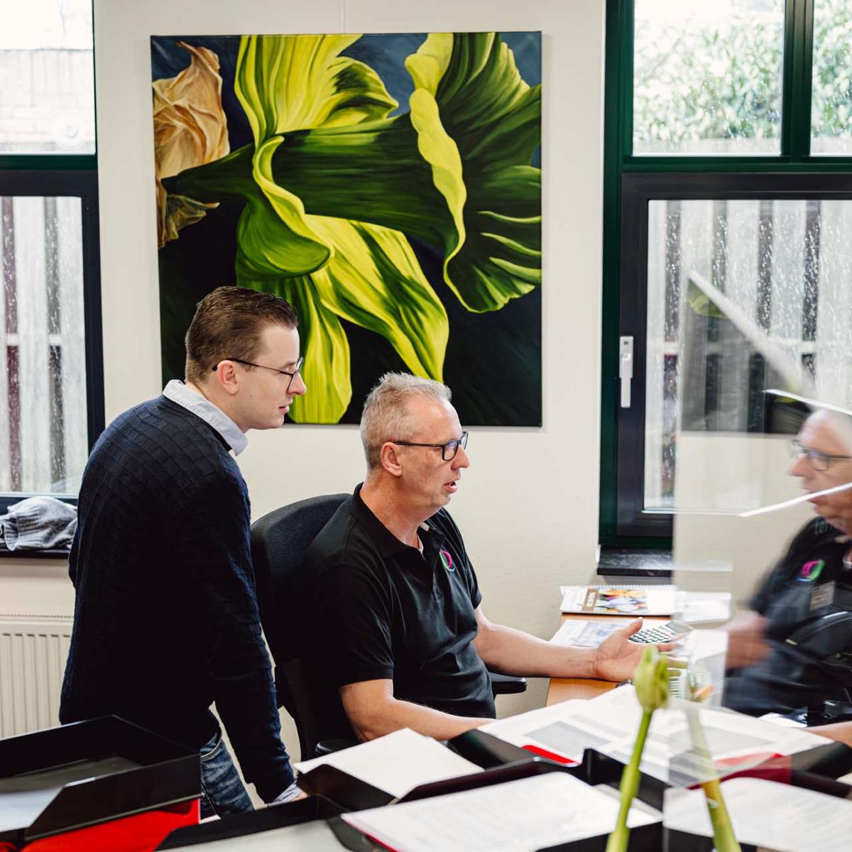Twee mannen op kantoor kijken naar computerscherm.
