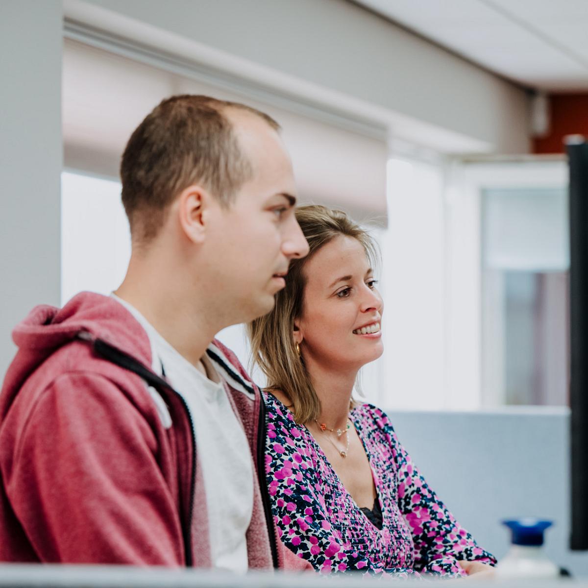 Smart Bulb collega’s werken samen achter een computer op kantoor in Noordwijkerhout.